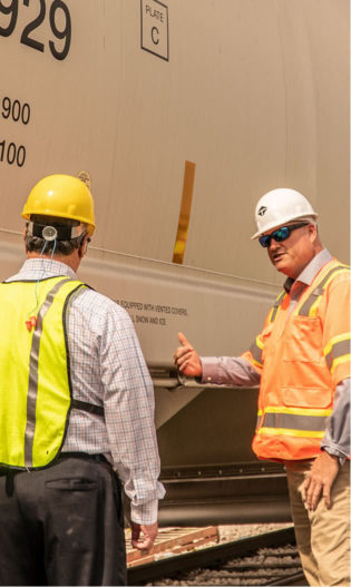 Two employees discussing a railcar