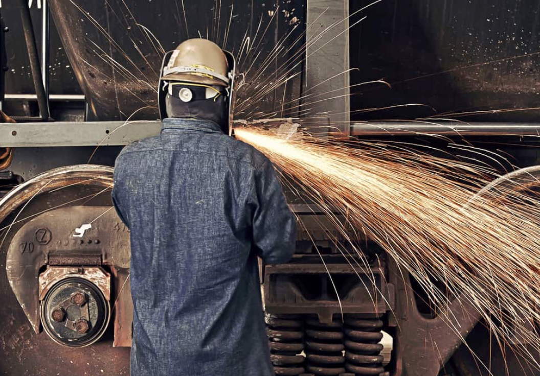 A welder maintains a railcar.