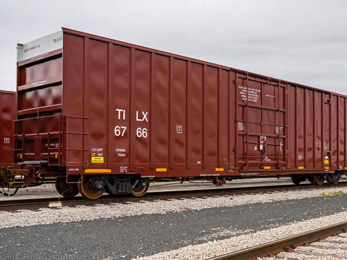 A red box car sits on a track