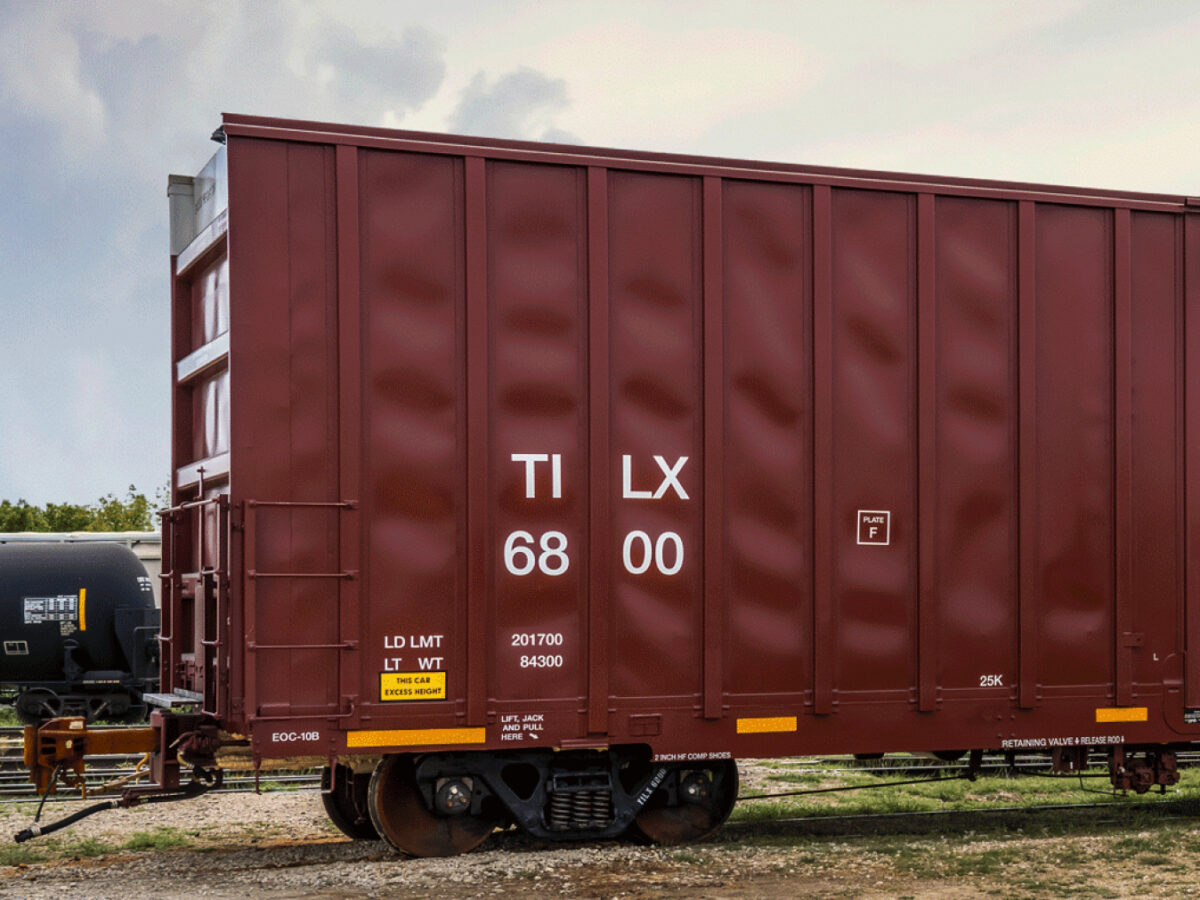 A red box car waits in a railyard