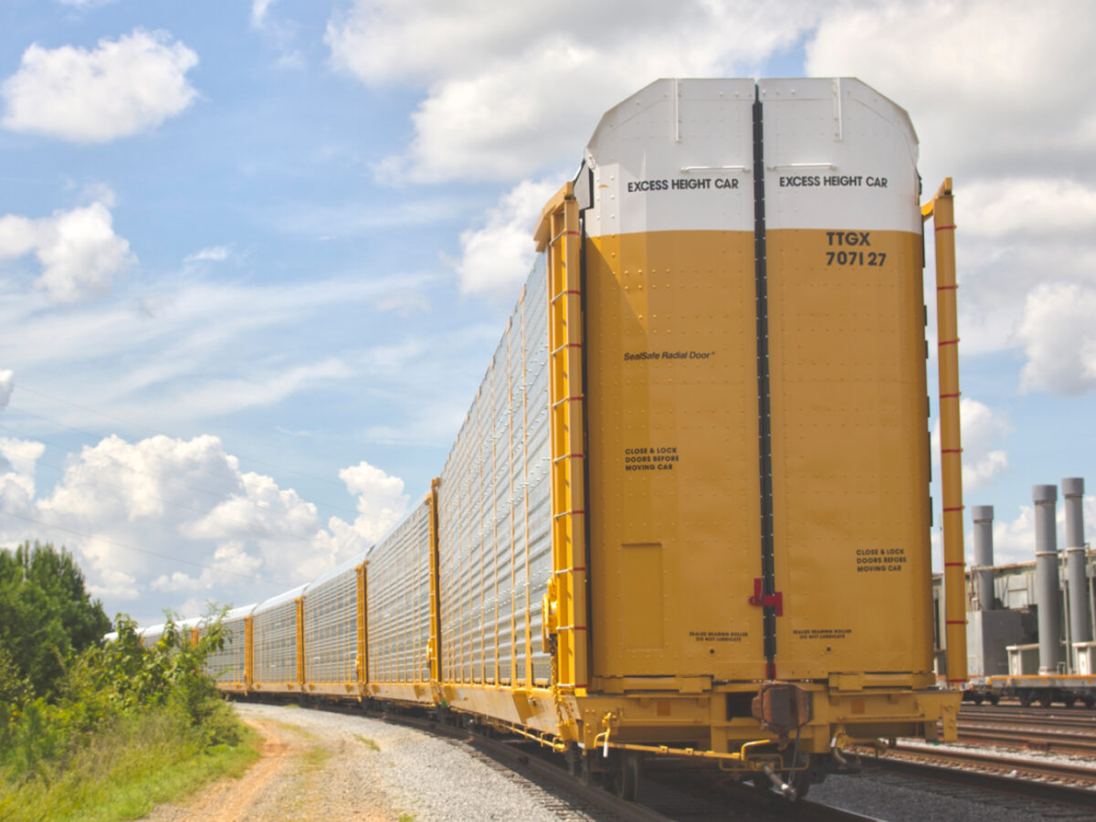 A line of yellow, tri-level autorack cars